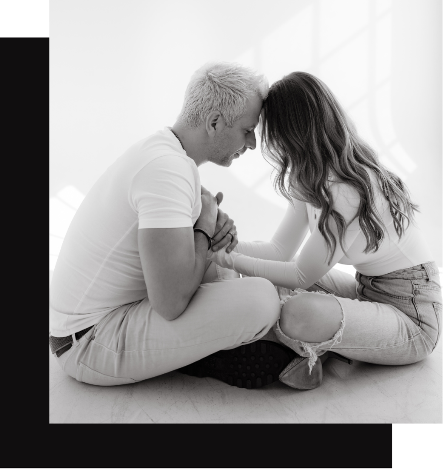 A couple sitting on the floor holding hands
