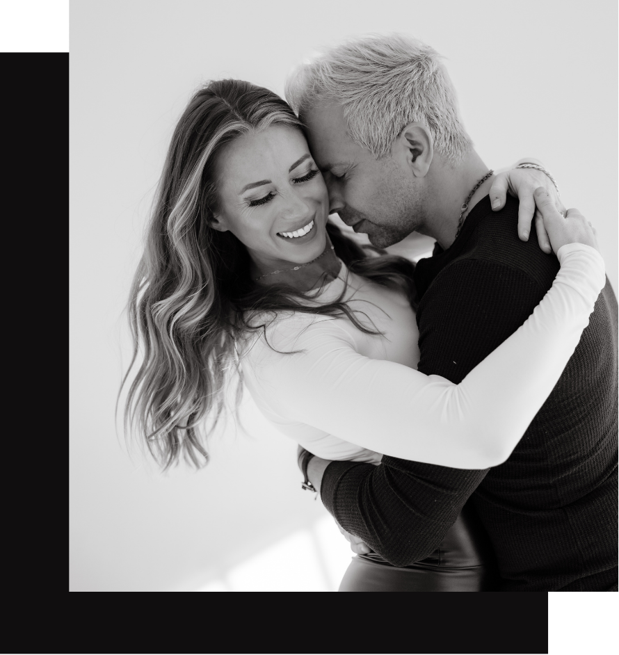 A couple embracing and smiling in bright light